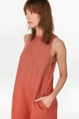 Vestido midi verde de lino italiano, con diseño sin mangas, cuello redondo y estampado de líneas onduladas punteadas. Cuenta con bolsillos laterales.