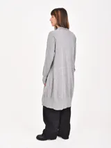 Saco tipo cárdigan largo de tejido de punto, con diseño de rayas horizontales en negro y beige. Presenta frente abierto, mangas largas y dos bolsillos delanteros.