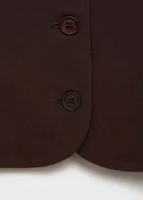 Chaleco marrón con cuello cuadrado, sin mangas y cierre frontal con botones.