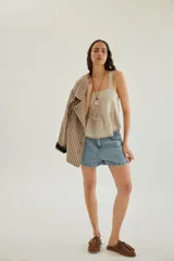 Short de jean de tiro alto con pinzas en la parte delantera, bolsillos y cierre frontal con botón metálico.