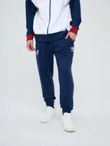 Pantalón deportivo azul marino con puños elásticos en los tobillos, bolsillos laterales con cierre, escudo del Club Nacional de Football en una pierna y logo de Umbro en la otra.