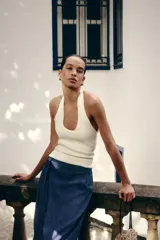 Top color crema de tejido de punto con cuello halter y escote redondo.