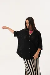 Camisa negra de tejido calado, con escote en V, abotonada y manga 3/4.