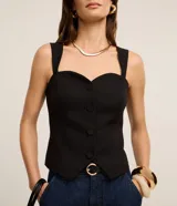 Blusa de sastrería color blanco, sin mangas, con escote corazón, breteles anchos, botones frontales forrados y bajo en V.