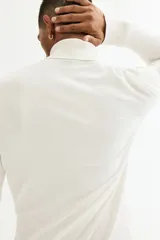 Buzo de punto fino con cuello alto acanalado, manga larga y terminaciones en puños y bajo acanalados. Presenta un corte estándar y diseño liso.