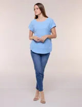 Blusa celeste de tejido pointelle calado, con escote redondo, mangas cortas con dobladillo y presilla con botón, y ruedo curvo.
