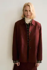 Chaqueta de tejido suave con acabado efecto gamuza, cuello camisero, cierre frontal con botones y bolsillos delanteros insertados.