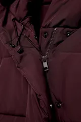 Campera puffer acolchada de color negro, con cuello envolvente, capucha integrada, manga larga, bolsillos laterales ocultos y bajo con elástico. Cierre frontal con botones a presión ocultos por solapa.
