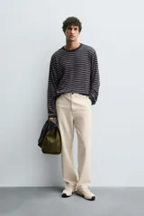 Pantalón chino de corte recto confeccionado en tejido ligero de algodón con estructura canvas. Presenta bolsillos frontales, bolsillos traseros de vivo y cierre frontal con cremallera y botón.