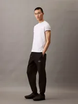 Pantalón de jogging negro con cintura elástica y logo monograma de Calvin Klein en color gris claro en el muslo izquierdo.