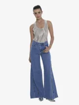 Pantalón de jean azul de calce regular y silueta wide leg. Presenta un cierre metálico exterior que recorre el largo de la pierna, aportando un detalle distintivo.