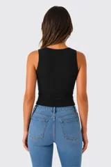 Top sin mangas al cuerpo, de color blanco, confeccionado en tejido acanalado, con diseño cut-out frontal en el escote.