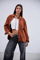 Sobrecamisa de gamuza color terracota, con cuello clásico, cierre frontal de botones metálicos, bolsillos en el pecho y mangas largas con puños abotonados.