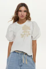 Blusa azul marino de algodón, con mangas abullonadas cortas de tela plana y gran bordado de rosa en tono crudo en el pecho.