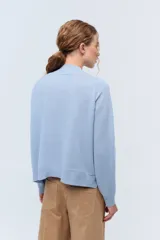 Sweater de tejido de punto color beige, con escote en V y calce holgado.