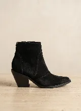 Bota corta de cuero vacuno color negro, con taco cuadrado de 7 cm y punta ligeramente afinada. Presenta costuras decorativas laterales y cierre interno.