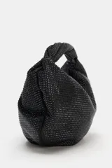 Bolso de mano negro con cuerpo cubierto de apliques brillantes, diseño estructurado con asa superior integrada y cierre principal. Incluye bolsillo interior con cremallera y cadena para usar como bandolera.