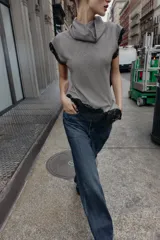 Top sin mangas con cuello subido, confeccionado en tejido con estampado pata de gallo. Presenta un diseño asimétrico en el bajo decorado con encaje negro, detalle que también se encuentra en las sisas.