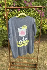 Remera gris de manga corta con estampa de un trago y la frase "Última Ronda".