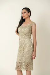 Vestido dorado de cruni con escote y espalda de tul transparente.