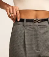 Pantalón de vestir de corte recto, confeccionado en tejido de punto roma con estampado de cuadros. Incluye trabillas en la cintura, cierre tradicional, pliegues y cinturón fino de material sintético con hebilla.