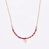 Colgante de cadena dorada con un arco central decorado con pequeñas cuentas de piedras semipreciosas en tonos rojos, rosados, naranjas y azules oscuros, intercaladas con tubos dorados. En el centro cuelga un racimo de tres perlas blancas irregulares.