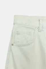Jeans de tiro medio con diseño barrel, cinco bolsillos y bajo con vuelta. Cuenta con cierre frontal de cremallera y botón metálico.