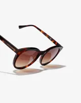 Gafas de sol Hawkers Resort unisex, con montura redonda de carey y lentes marrones degradadas.