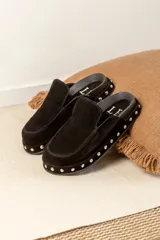 Zuecos tipo mule de cuero gamuzado negro, con plataforma forrada y detalle de tachas plateadas en el contorno. Presentan una plantilla con el logo bordado.