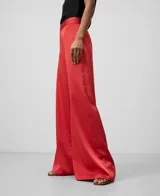 Pantalón de poliéster reciclado color rojo, de pierna ancha y con cierre de cremallera lateral.