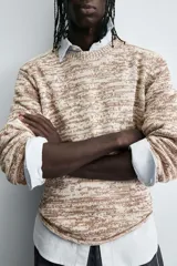 Jersey de punto con cuello redondo y manga larga, confeccionado en mezcla de algodón con textura jaspeada en tonos beige y marrón.