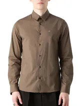 Camisa de vestir color marrón, corte slim, de popelín de algodón elástico, con cuello clásico, cierre frontal con botones y logo "ck" bordado en el pecho.