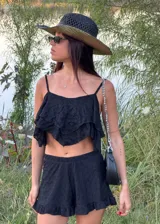 Top corto de tirantes finos en color blanco, con diseño de capas con terminación en punta y textura delicada en relieve.