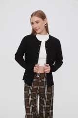 Saco negro de punto, con cuello redondo a la base, manga larga y cierre frontal con botones.