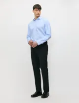 Camisa de vestir celeste de corte clásico, cuello italiano y manga larga con puños abotonados. Confeccionada en algodón premium, sin bolsillos.