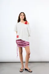 Minifalda de rayas verticales en tonos bordó y beige, confeccionada en tejido elástico con fruncidos laterales regulables mediante cordones.