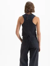 Chaleco de denim tipo sastrero color negro, de fit estándar, con escote en V, cierre frontal de botones y dos bolsillos de parche en el pecho.