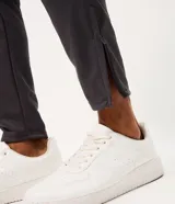Pantalón deportivo de corte ajustado con cintura elástica, cordón de ajuste, bolsillos con cremallera, franjas laterales en contraste y cremalleras en los bajos.