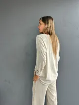 Blusa de textura liviana y diseño holgado, con cuello redondo y mangas tres cuartos.