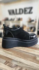 Zapatos de cuero color tostado con plataforma alta, cierre frontal y detalles en gamuza y textura símil cocodrilo en tonos dorados.