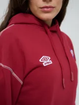 Canguro deportivo Umbro del Club Nacional de Football, color bordó, con capucha ajustable con cordón, bolsillo tipo canguro y costuras visibles en contraste. Presenta el logo de Umbro y el escudo del club bordados en el frente.