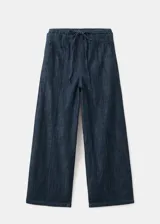 Pantalón de mezclilla azul oscuro, con silueta wide leg, tiro alto y pretina con cordón ajustable.
