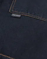 Bermuda de jean negra con dos bolsillos frontales tipo parche, costuras a contratono color ocre y botón de cobre.