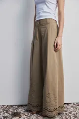 Pantalon de pierna ancha y tiro alto color marron, con bordado en contraste que recorre el ruedo y detalles en calado.