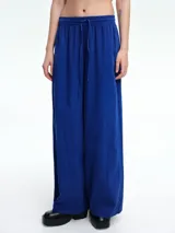 Pantalón de corte amplio y relajado, color azul, con cintura elástica y cordón ajustable.