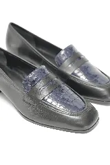 Mocasín de cuero negro liso combinado con cuero texturado en la capellada, con punta redondeada y taco medio ancho.