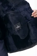 Campera de cuero tipo lambskin con diseño de paneles, cuello con solapas de piel sintética, cierre frontal con botones y bolsillos laterales.