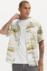 Camisa de hombre de manga corta con cuello clásico y estampado de paisaje con palmeras y montañas en tonos blanco, amarillo y verde.