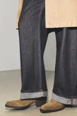 Botín estilo cowboy confeccionado en serraje, con detalle de pespuntes en el cuerpo, cierre lateral mediante cremallera y acabado en punta con tacón cuadrado.