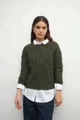 Sweater de tejido tramado en color verde oliva, con cuello redondo y mangas largas. Presenta un diseño de textura acanalada vertical.